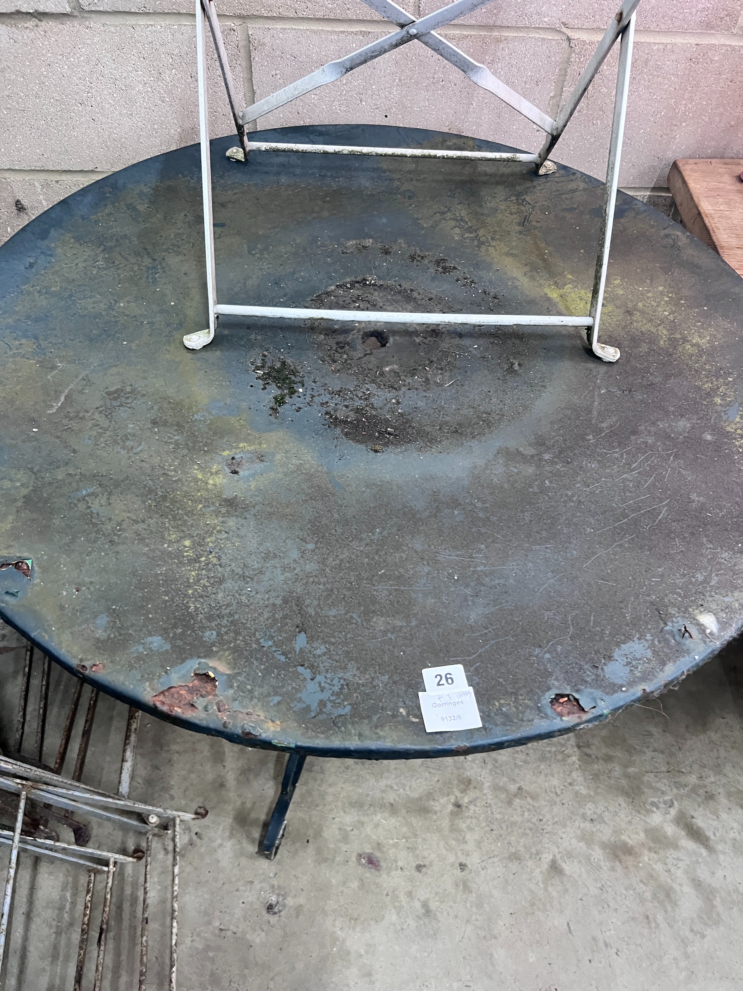 A circular metal and wrought iron garden table, diameter 90cm, and three chairs